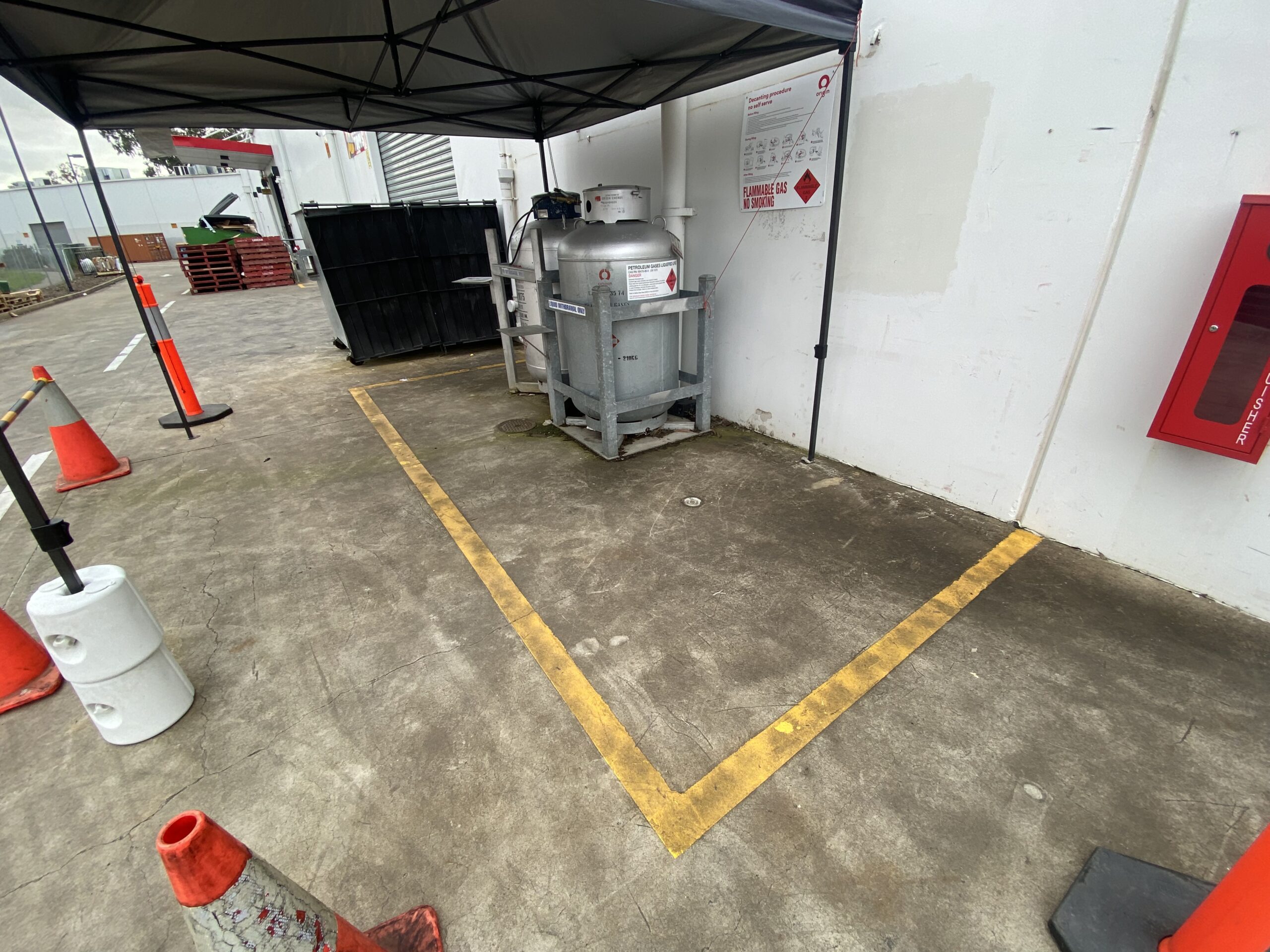 Concrete floor with safety cones and equipment in an outdoor service area.