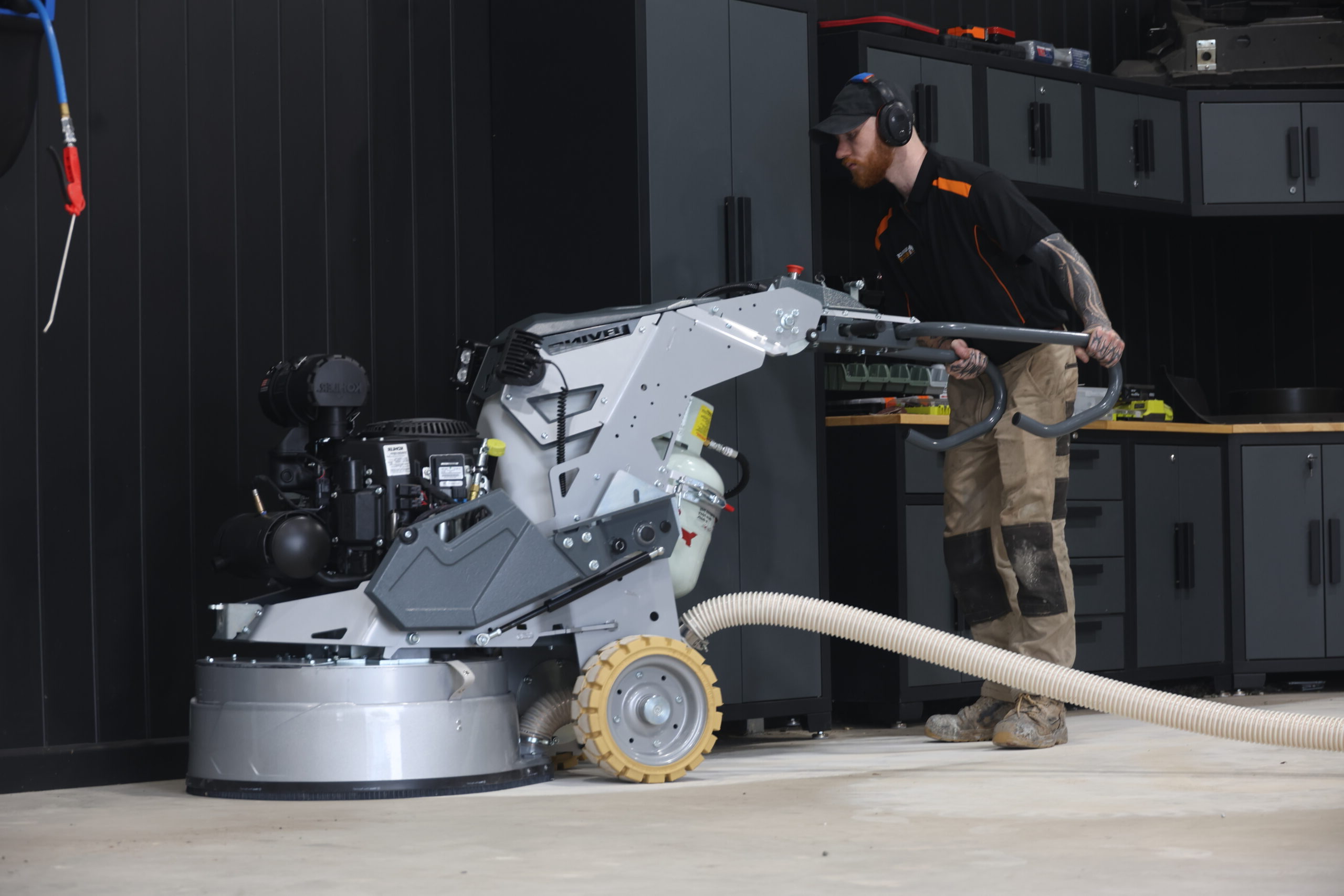 Professional using equipment for concrete resurfacing in a modern workshop.