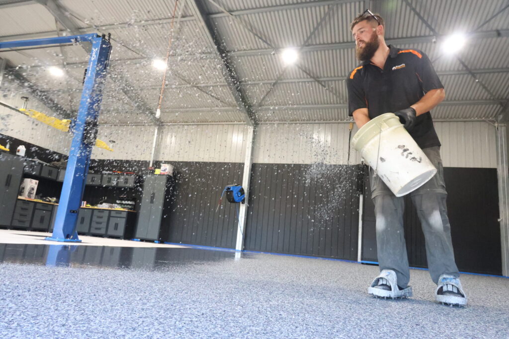 Professional applying resurfacing material on a floor in an Adelaide workshop.