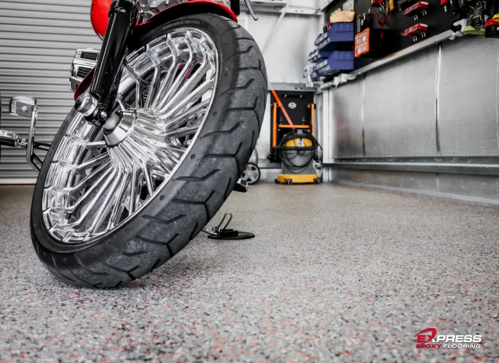 Motorcycle wheel on a clean garage floor with tool cabinets in the background