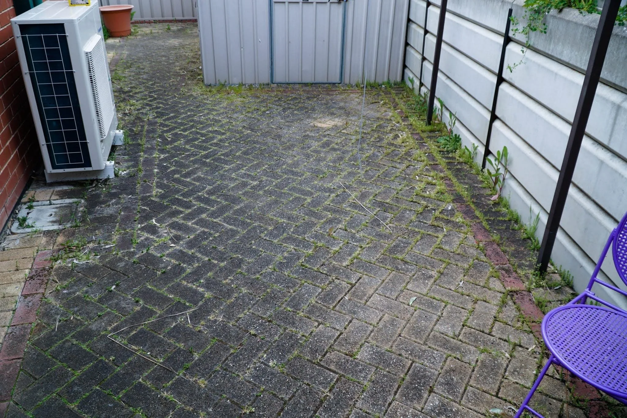 Exterior Cleaning Adelaide, removing moss and dirt from brick paving in an outdoor courtyard