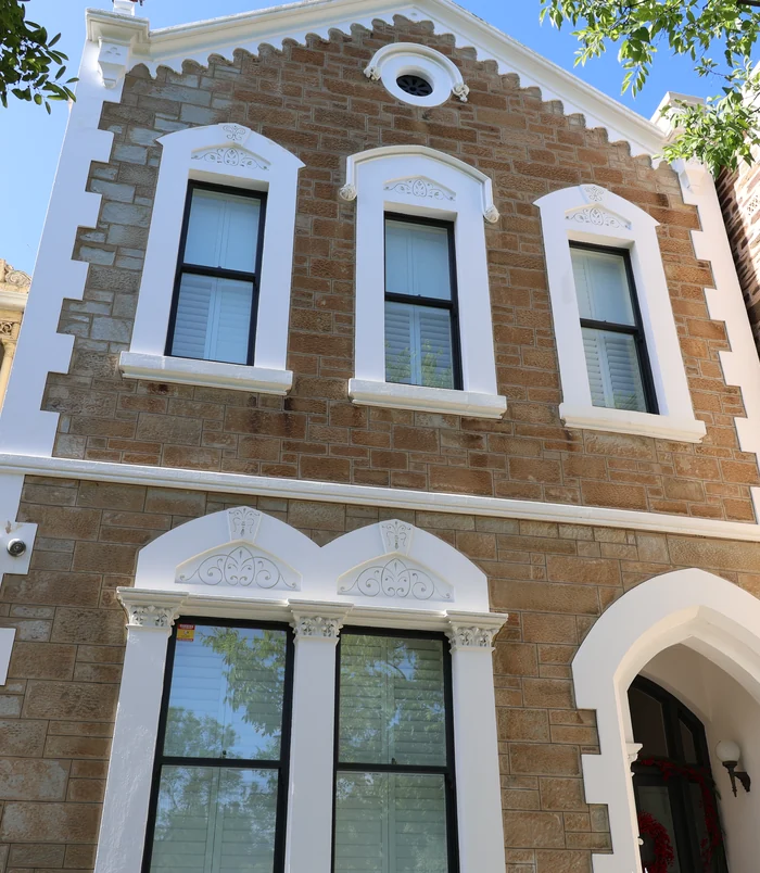 Heritage sandstone and brick building with arched windows, clean and bright after pressure washing