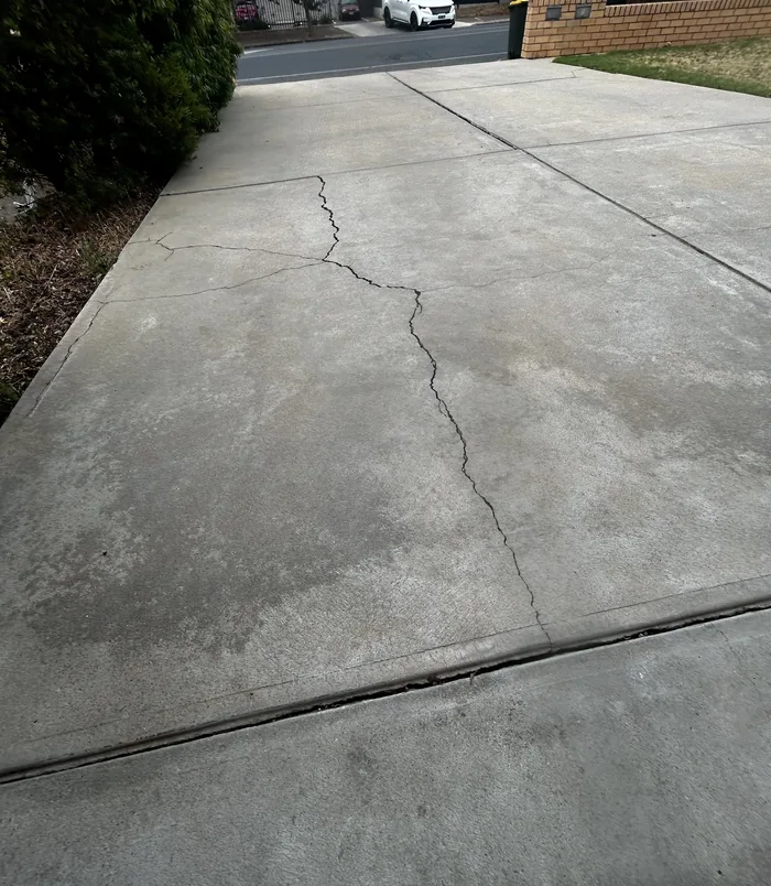 Cracked, weathered concrete driveway with stains, before concrete resurfacing