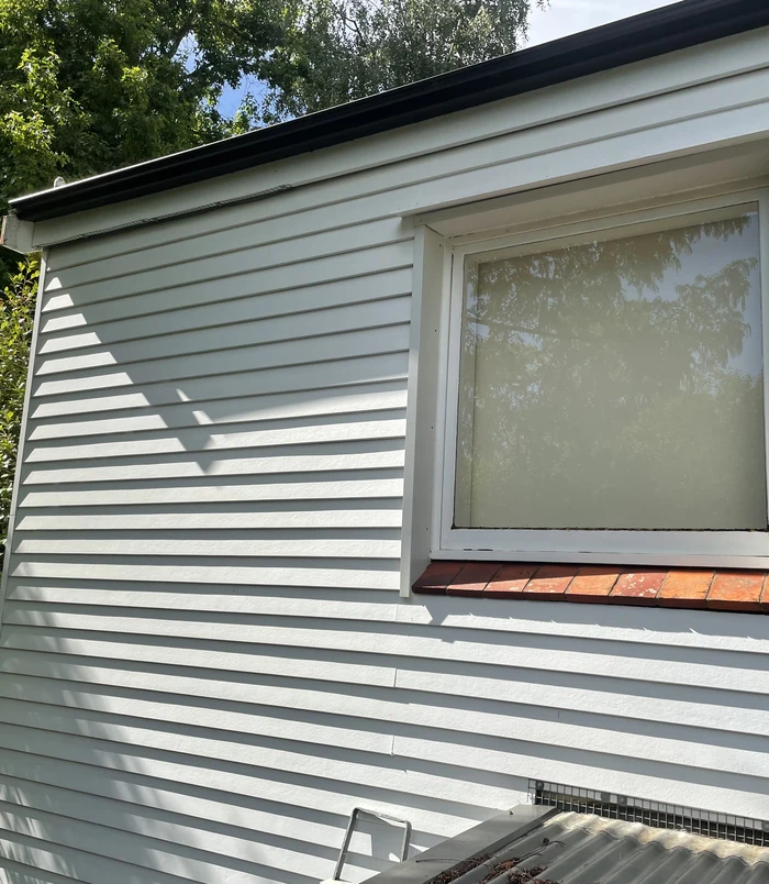 Clean weatherboard wall with a window after pressure washing