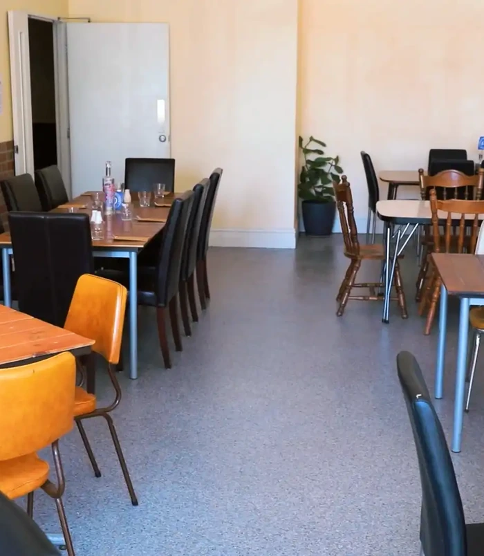 Restaurant dining room with timber tables and chairs on a dark, glossy epoxy floor