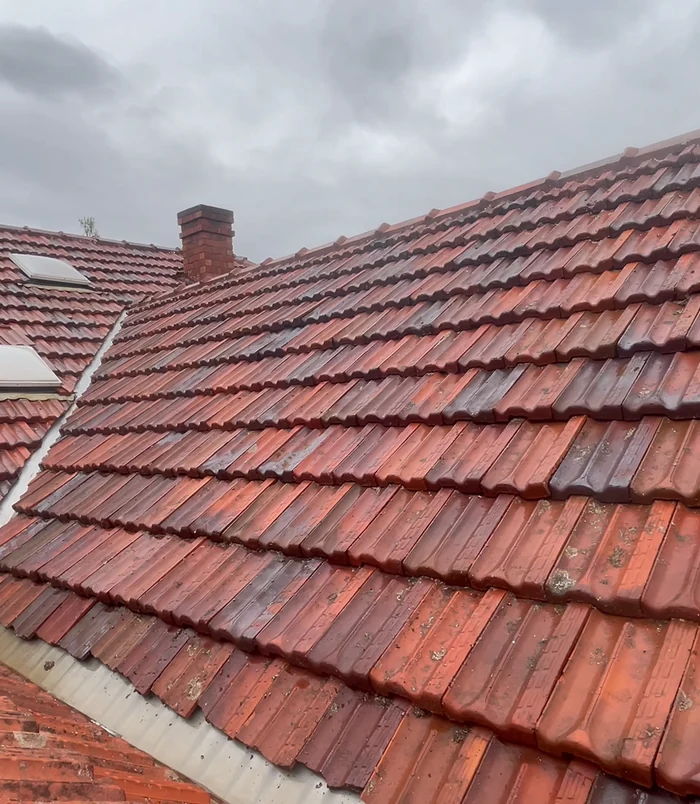 Clean red tiled roof with a chimney and restored, vibrant colour after pressure washing