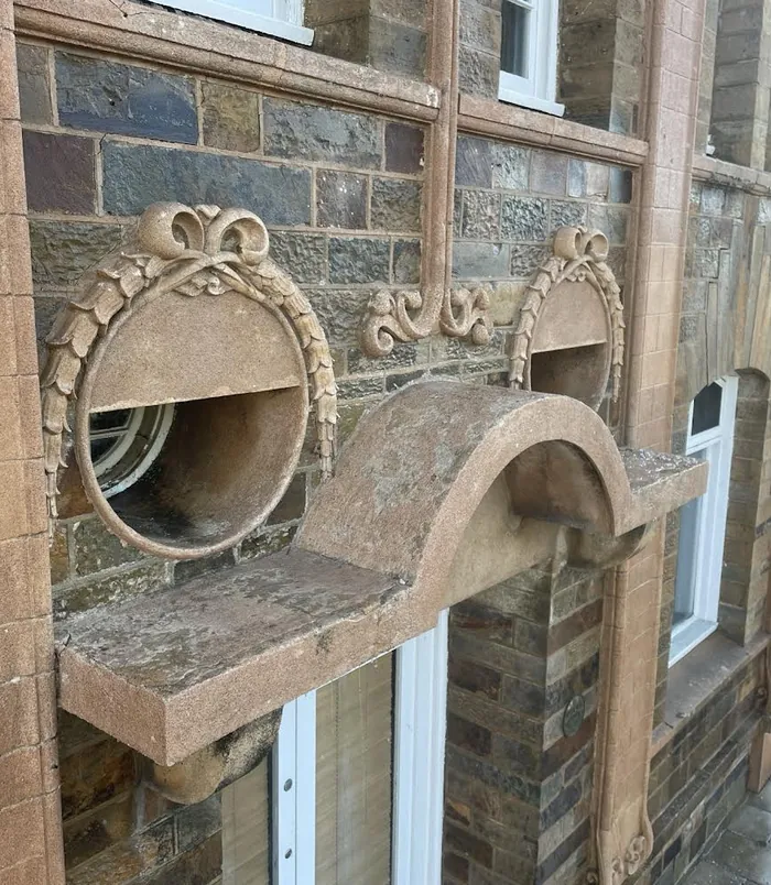 Ornate carved stone detail on a heritage building, clean and bright after pressure washing
