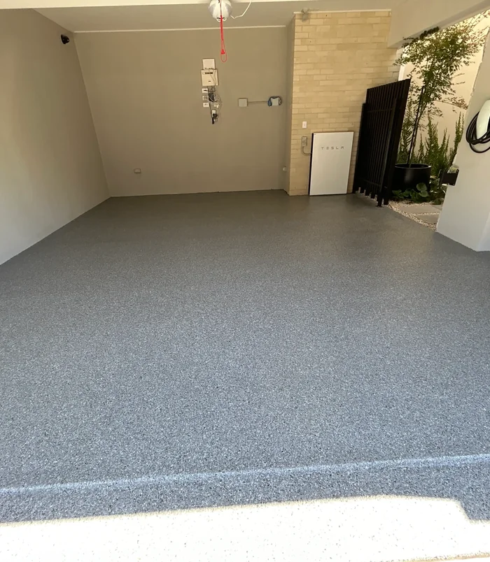 Grey speckled epoxy flake garage floor with a smooth, even finish