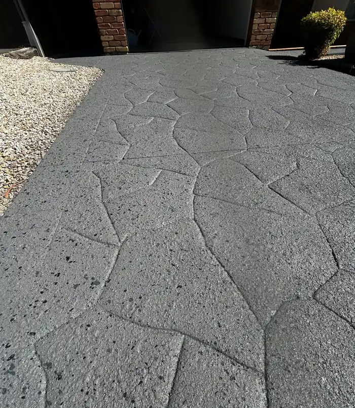 Dark grey resurfaced stamped-pattern concrete patio with a refreshed, even finish
