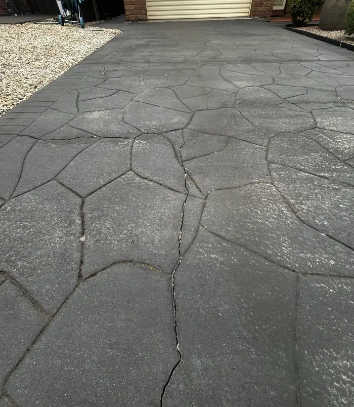 Cracked, weathered stamped-pattern concrete patio, before concrete resurfacing