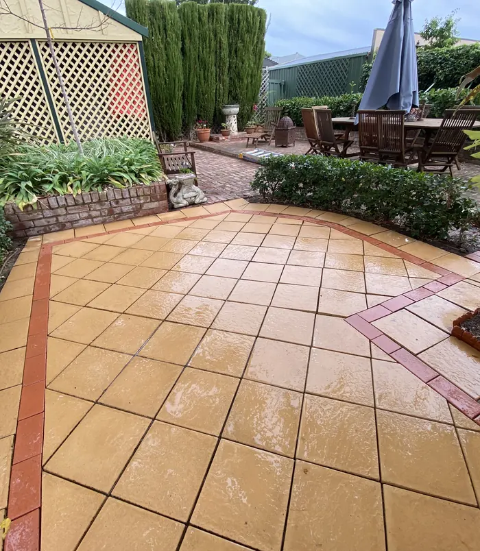Clean, warm terracotta patterned pavers in a garden courtyard after pressure washing