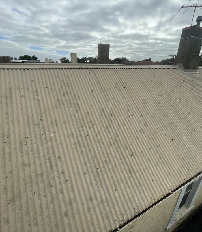 Clean corrugated iron roof with an even grey finish after pressure washing