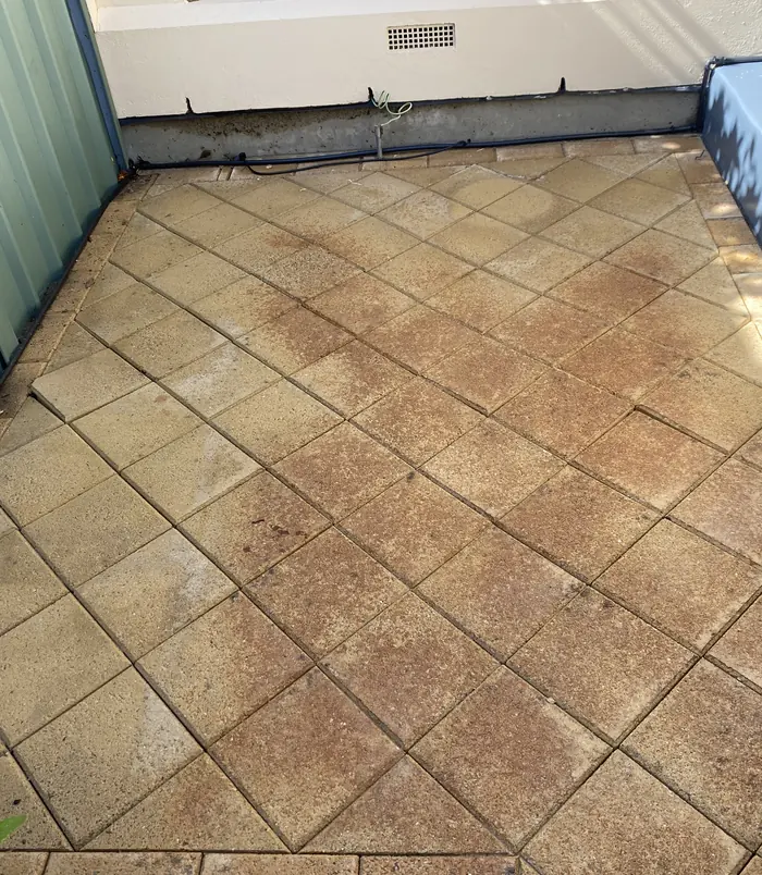 Clean square pavers with a warm, even colour in a courtyard after pressure washing