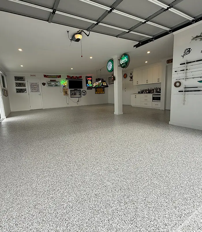 Grey epoxy flake garage floor in a workshop with memorabilia on the walls