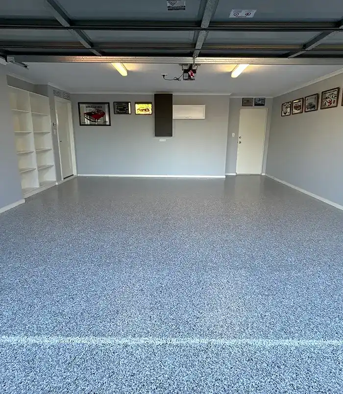 Grey epoxy flake garage floor with built-in shelving and wall displays