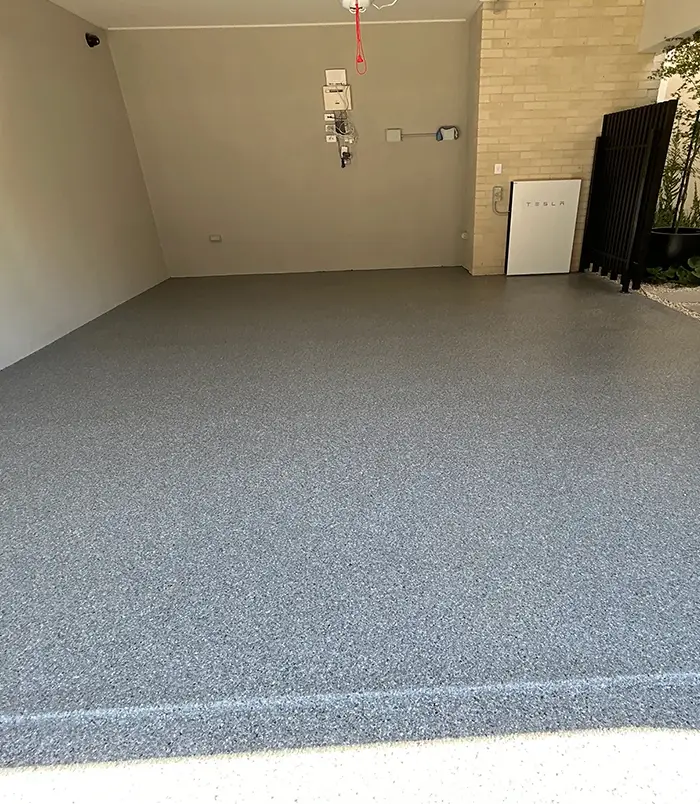 Grey speckled epoxy flake garage floor with white walls