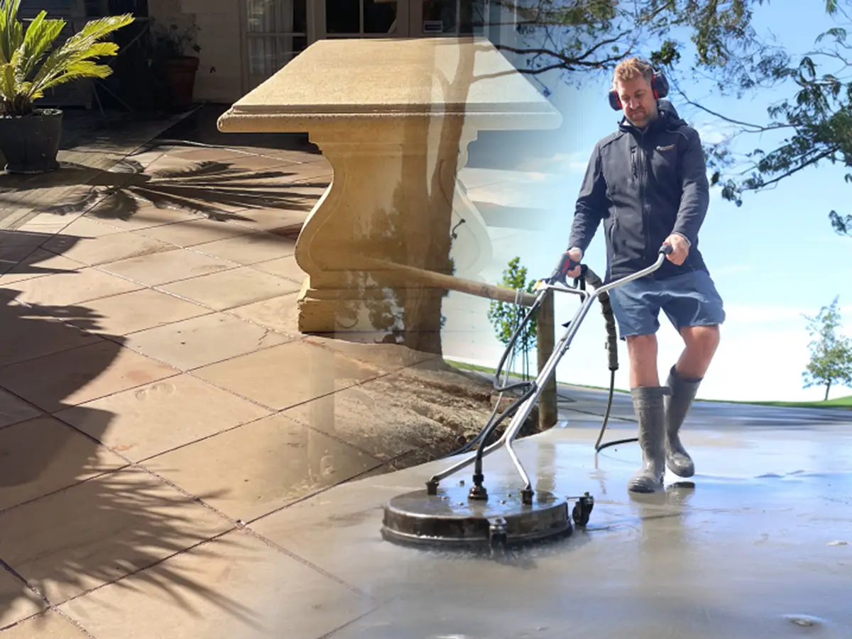 Surface Rescue technician using a surface cleaner on stone pavers beside a sandstone outdoor table