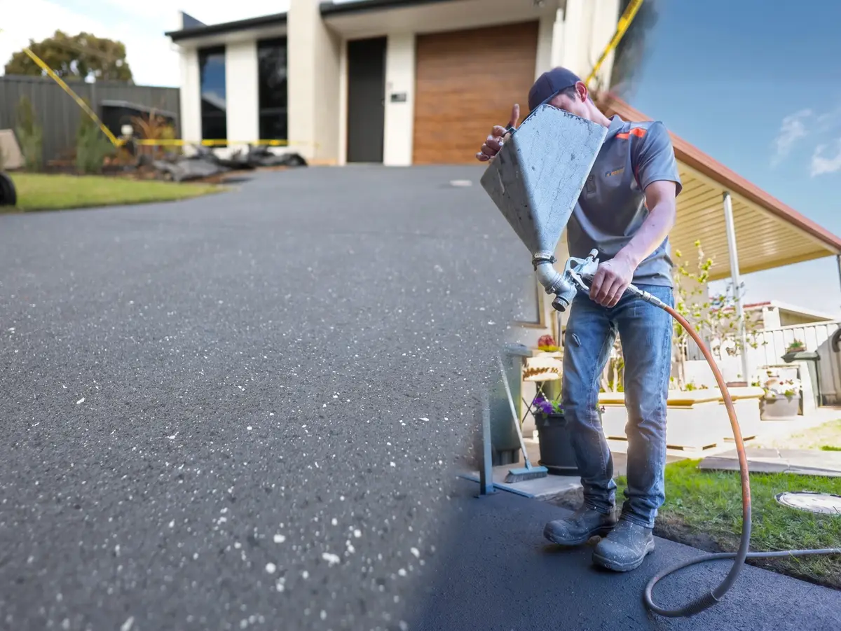 Surface Rescue technician working on a dark driveway in front of a modern home