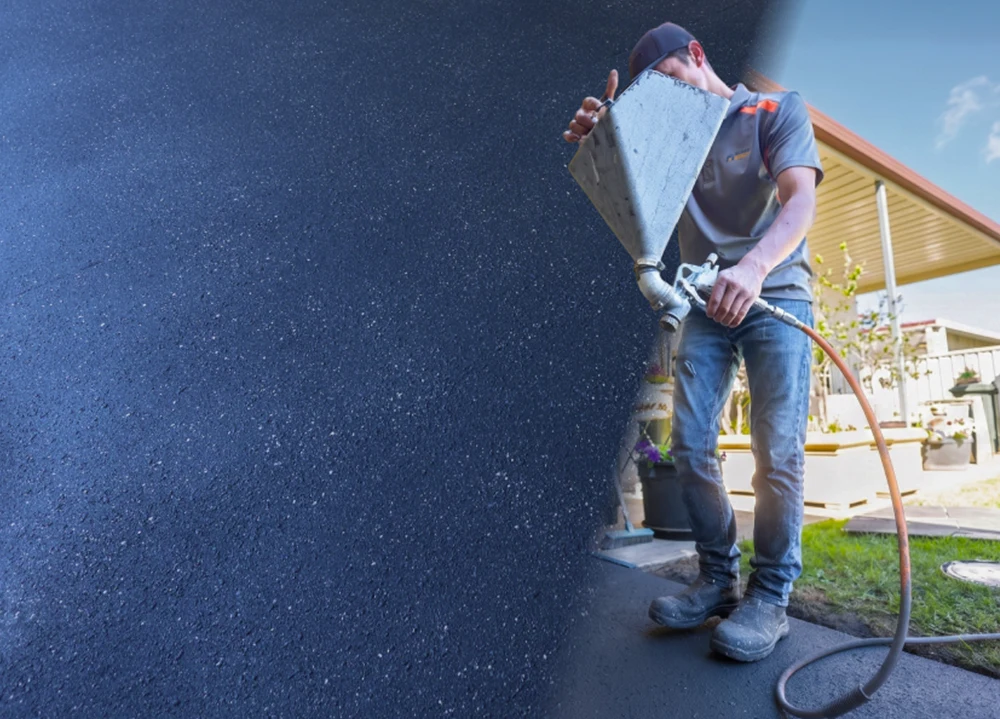 Surface Rescue technician holding a hopper over a dark speckled floor coating