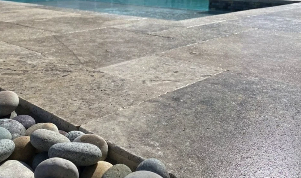 Close-up of grey patterned concrete paving beside a swimming pool