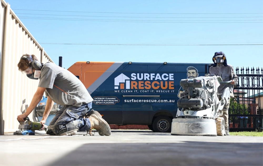 Surface Rescue technician beside a branded blue and orange service van with a floor grinder