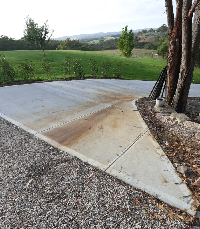 Concrete slab before sealing, with rust-coloured stains and discolouration across the surface